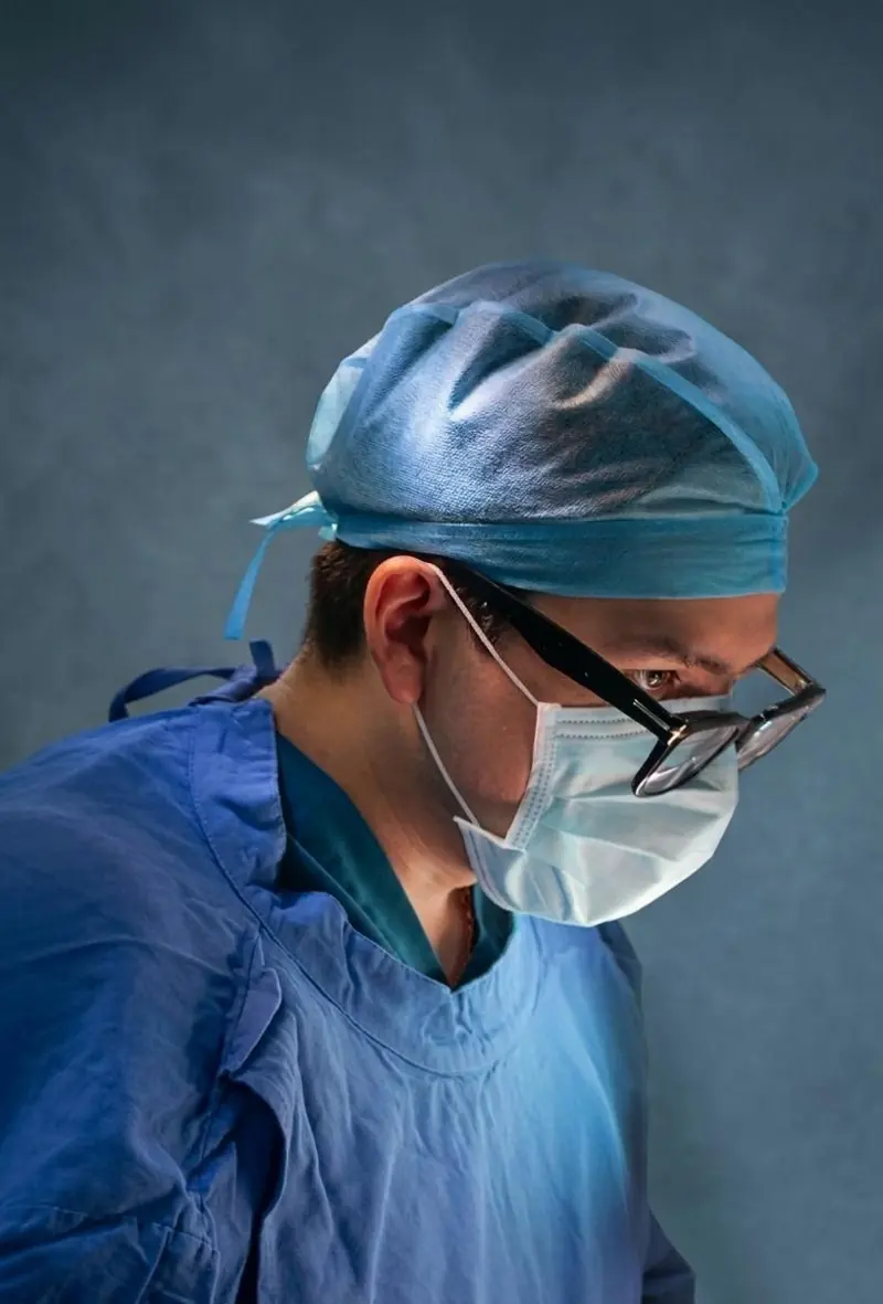 Dr. Sadid Villarreal, cirujano laparoscopista, con gorro, cubrebocas y lupas quirúrgicas durante una cirugía